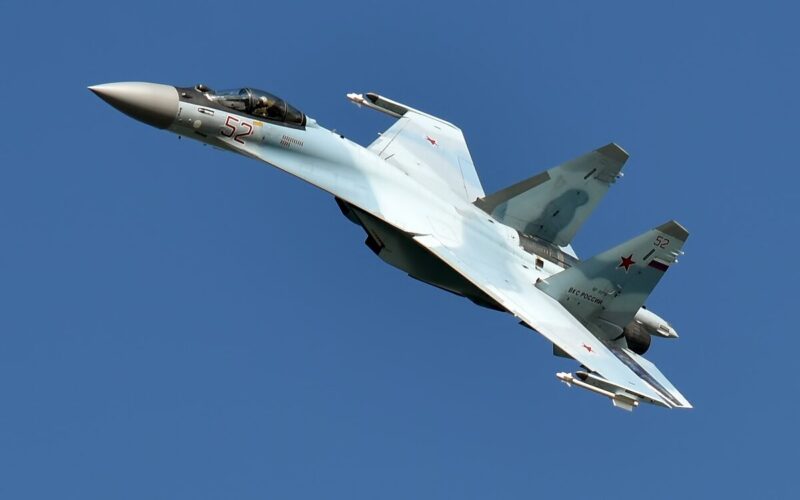 The Sukhoi Su 35 in a steep turn against a blue sky