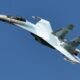 The Sukhoi Su 35 in a steep turn against a blue sky