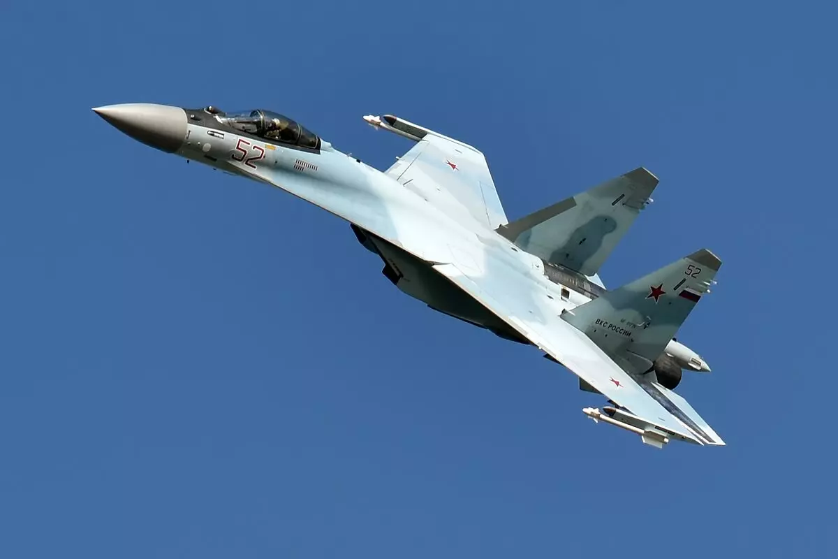 The Sukhoi Su 35 in a steep turn against a blue sky