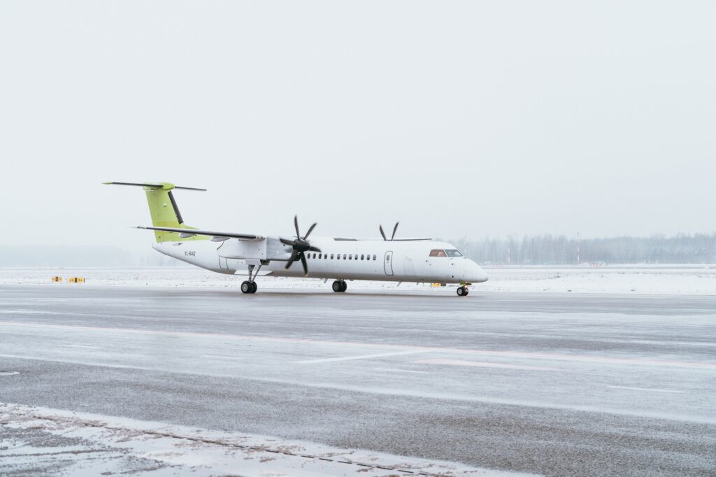 airBaltic Q400 aircraft on a snowy runway in Riga Airport before its redelivery
