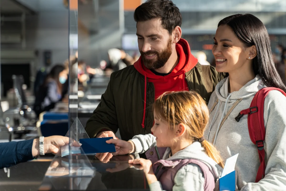 Passengers checking in at an airport counter Passengers checking in at an airport counter