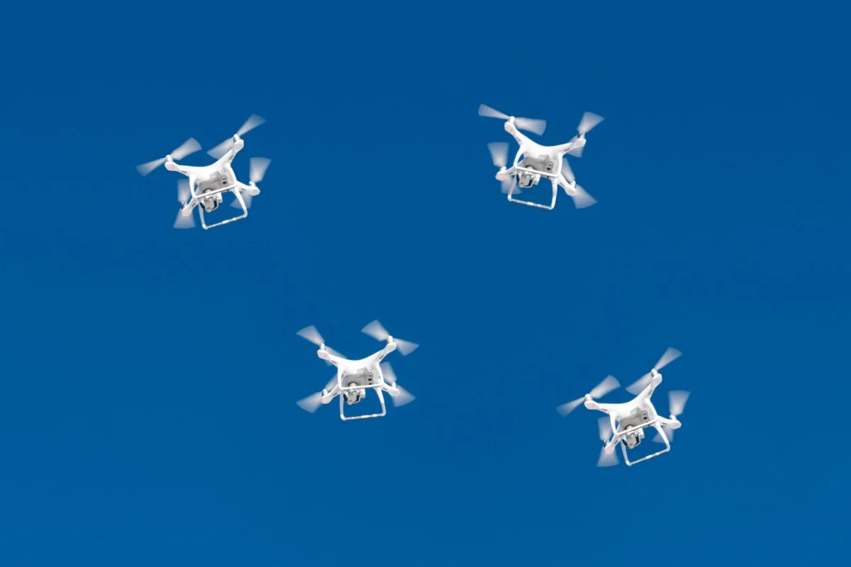 A drone swarm flying in a blue sky