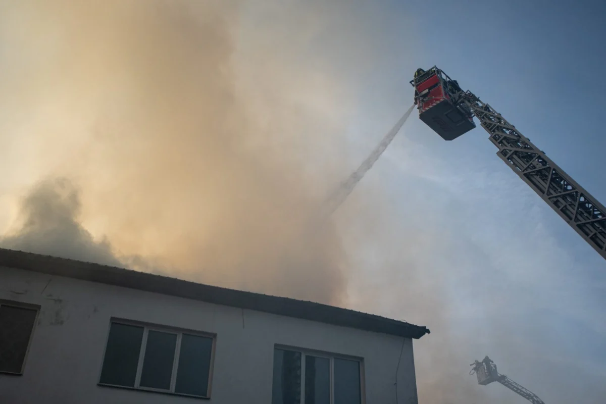 Firefighters using aerial equipment to battle a massive fire Firefighters using aerial equipment to battle a massive fire