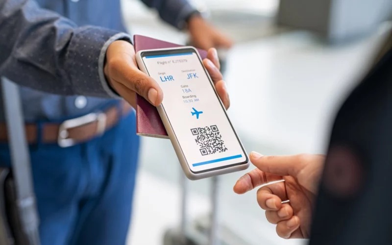 Agent checking electronic flight ticket at boarding gate