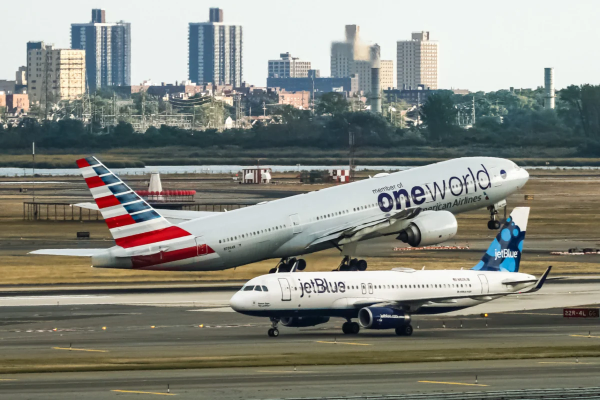 American Airlines Boeing 777 taking off from John F Kennedy International Airport with the jetBlue Airbus A320 taxing behind it