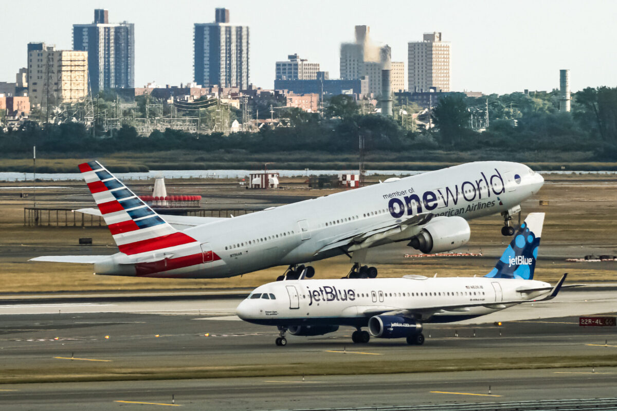 American Airlines Boeing 777 taking off from John F. Kennedy International Airport with the jetBlue Airbus A320 taxing behind it