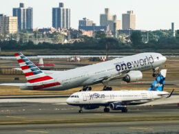 American Airlines Boeing 777 taking off from John F. Kennedy International Airport with the jetBlue Airbus A320 taxing behind it