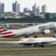 American Airlines Boeing 777 taking off from John F. Kennedy International Airport with the jetBlue Airbus A320 taxing behind it