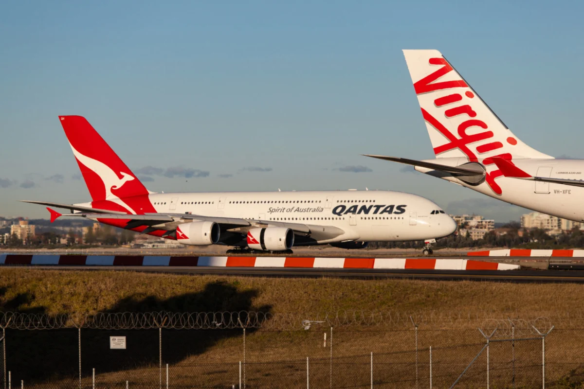 Qantas Airbus A320 taxiing behind Virgin Australia aircraft