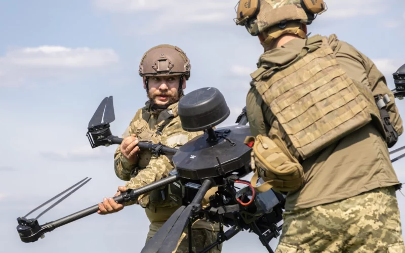Ukrainian soldiers carrying a Baba Yaga heavy drone