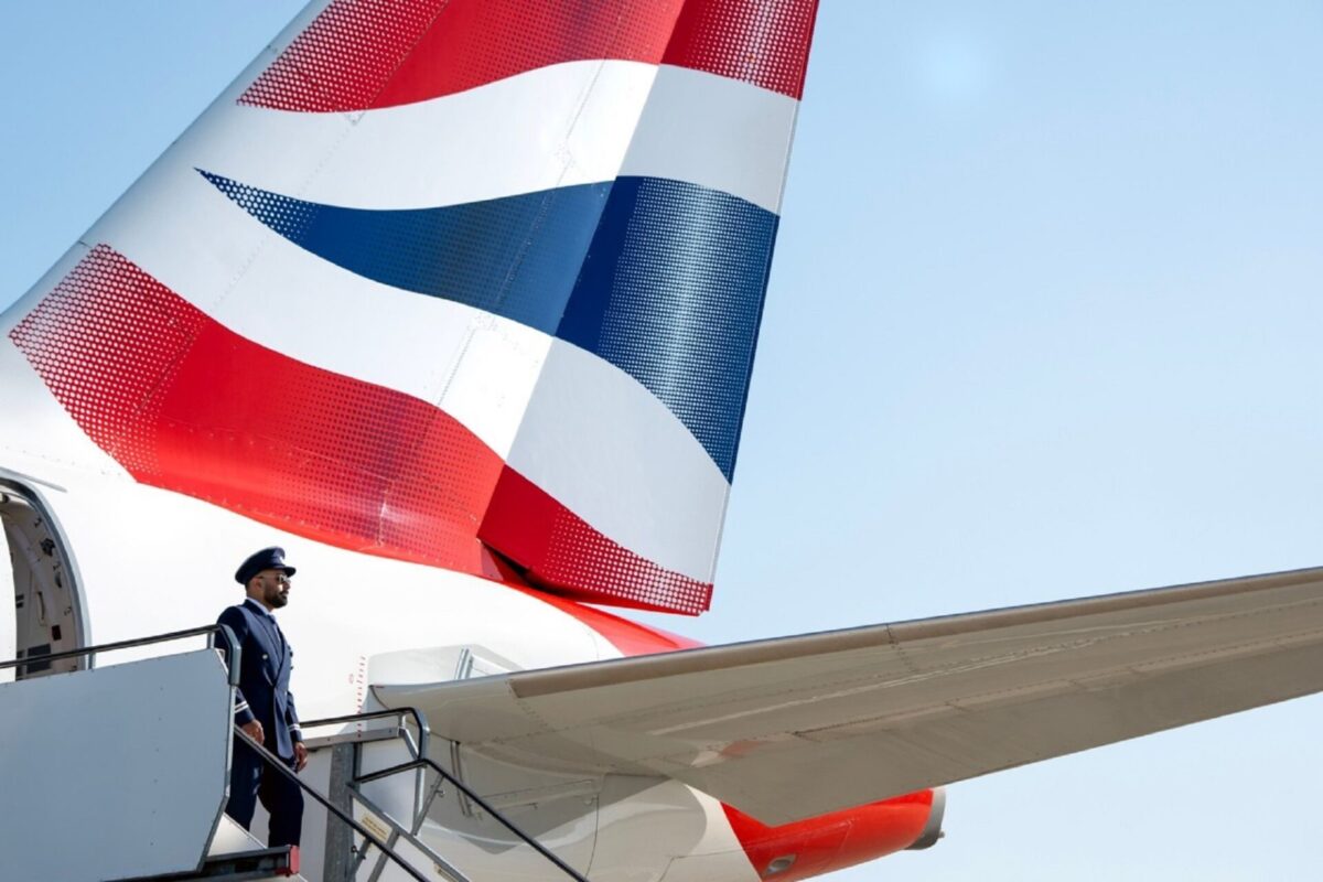 Euroflyer pilot by aircraft tailfin at Gatwick Airport airside BA Euroflyer