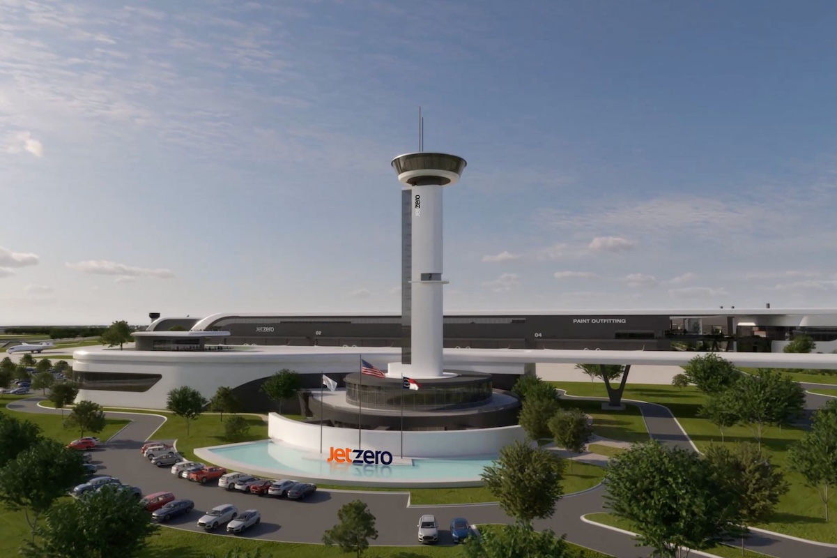 Rendering of Jet Zero facility with a tall controltower structure and circular base surrounded by a curved white building and parking lot with cars and trees