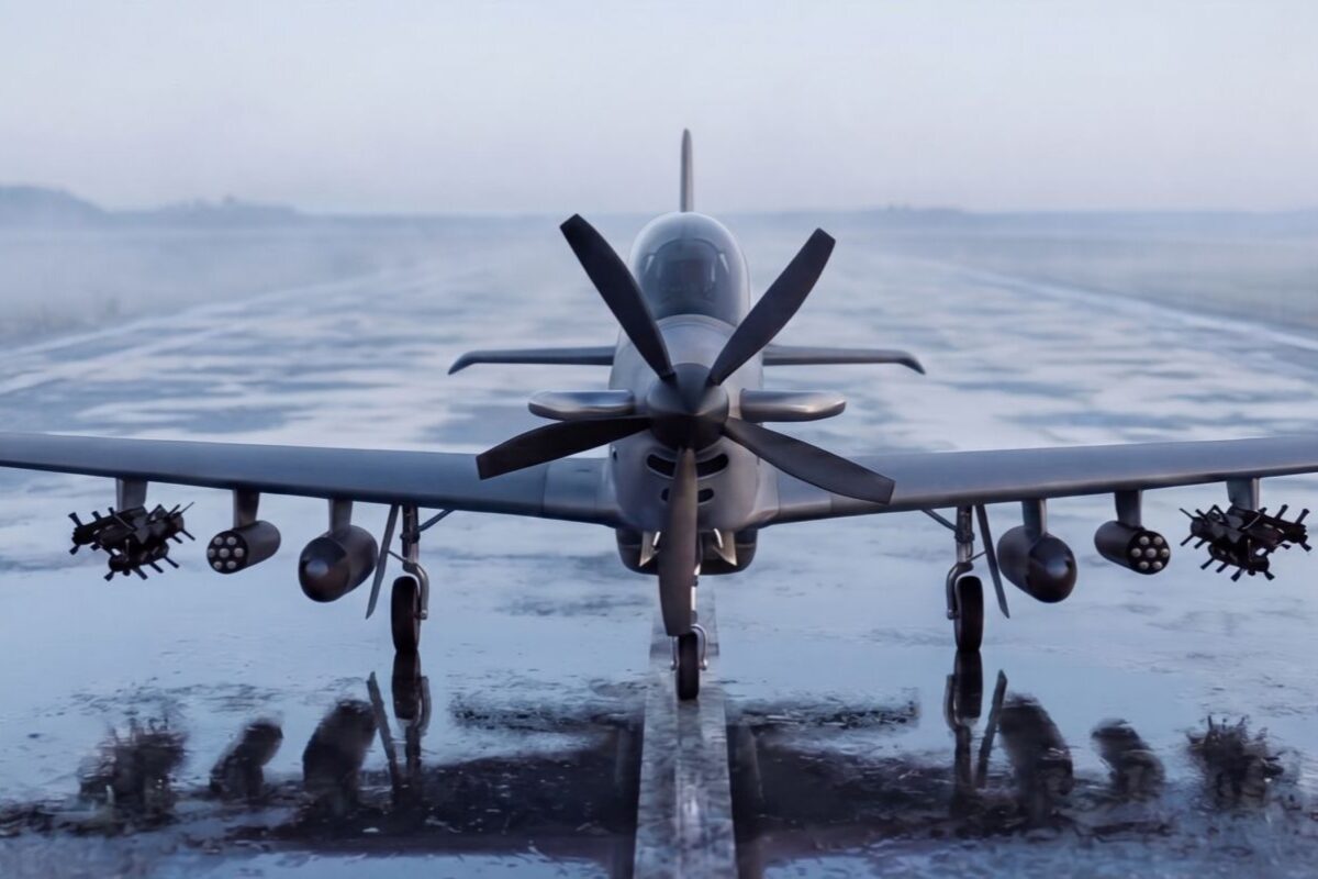 2100x802 Front view of a military jet on an icy runway with weapons mounted under the wings and its reflection visible on the wet surface of the tarmac