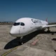 Qantas airliner parked at the gate on a sunny day with a jet bridge nearby