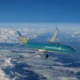 Vietnam Airlines passenger jet in turquoise livery cruising above white clouds