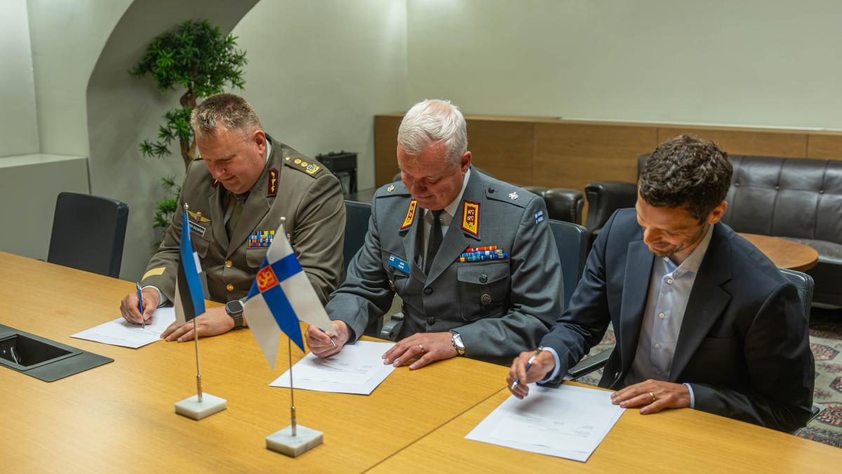 Estonia Finland NestAI sign joint AI partnership Estonian and Finnish military officials and a NestAI representative sign documents at a conference table with Estonian and Finnish flags in front of them