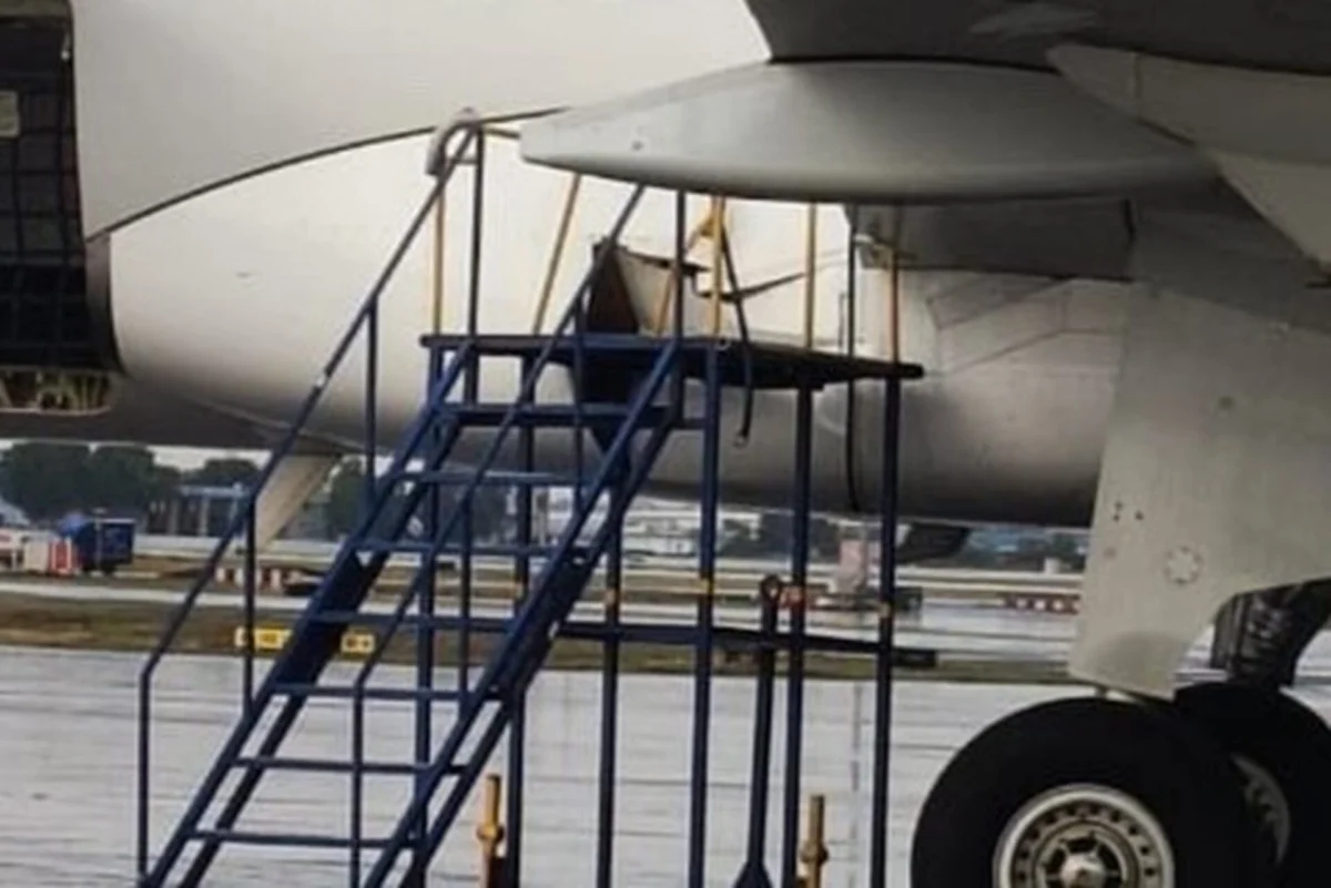 Close up view of a jet engine nacelle with blue boarding stairs parked at the wing on the tarmac