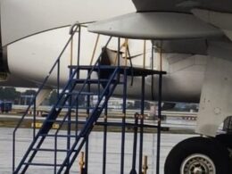 Close up view of a jet engine nacelle with blue boarding stairs parked at the wing on the tarmac