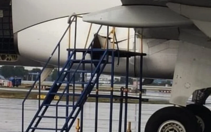 Close up view of a jet engine nacelle with blue boarding stairs parked at the wing on the tarmac