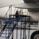 Close up view of a jet engine nacelle with blue boarding stairs parked at the wing on the tarmac
