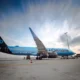 Blue La Compagnie Airbus A321neo parked on the tarmac with ground crew and orange cones nearby at an airport