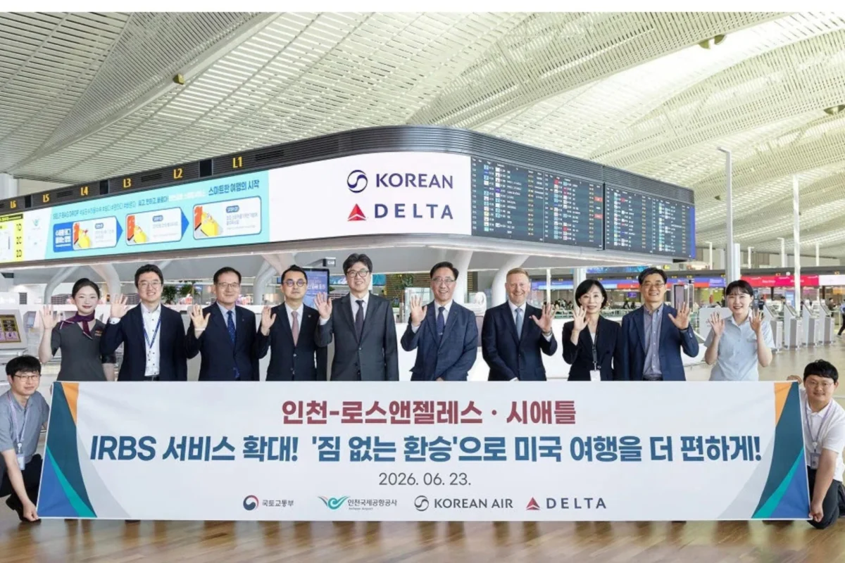 Korean Air Delta extend baggage transfer to five US hubs Group of professionals at an airport holding a large banner with Korean Air and Delta logos visible date 20260623 and flight information boards in the background