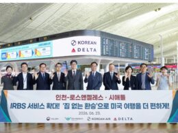 Group of professionals at an airport holding a large banner with Korean Air and Delta logos visible date 20260623 and flight information boards in the background