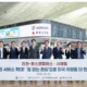 Group of professionals at an airport holding a large banner with Korean Air and Delta logos visible date 20260623 and flight information boards in the background