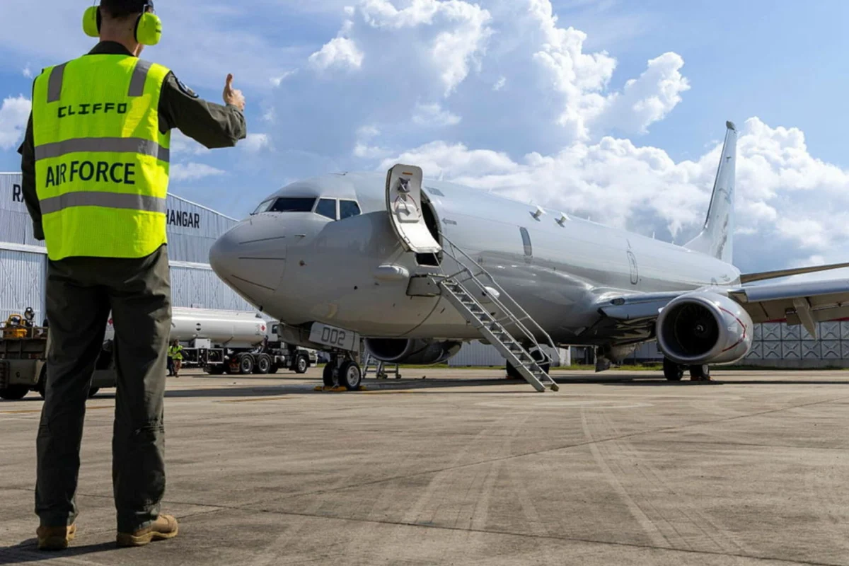RAAF sends P 8A Poseidon and E 7A Wedgetail to RIMPAC 26 Ground crew member in a neon safety vest gives a thumbs up beside a parked jet with portable stairs
