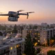 Quadcopter drone flying over a residential neighborhood at sunset with low rise buildings and trees below