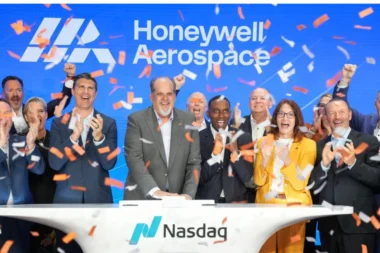 Group of diverse executives celebrating on a Nasdaq stage with orange confetti and a blue Honeywell Aerospace backdrop