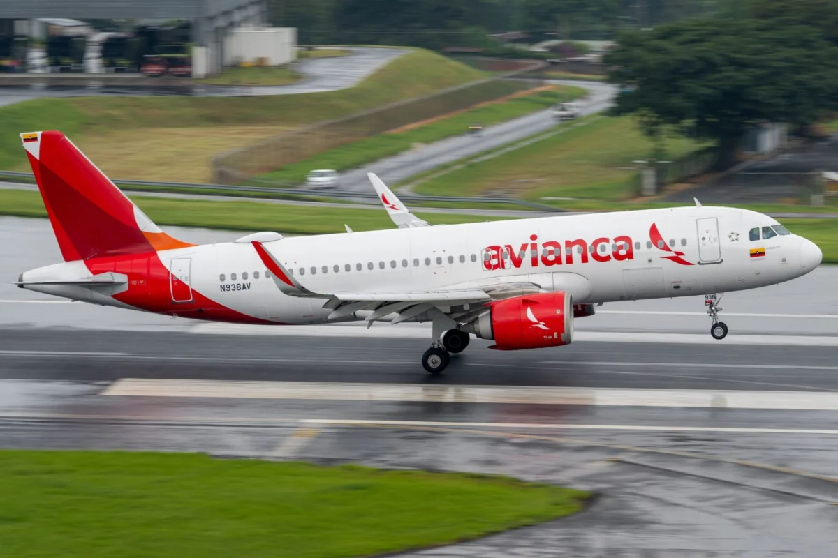 Avianca passenger jet taxiing on a wet runway red tail and logo visible