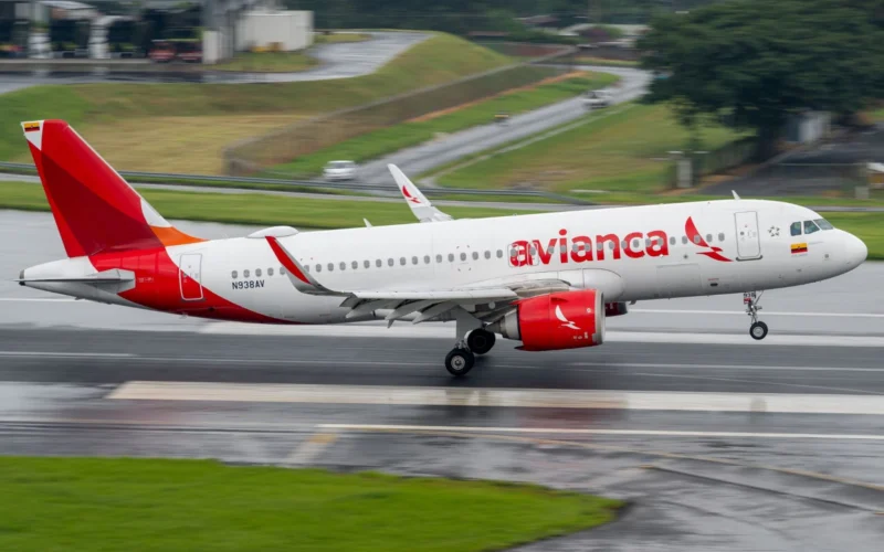 Avianca passenger jet taxiing on a wet runway red tail and logo visible