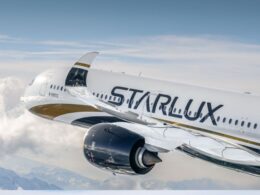 Commercial airliner in flight white fuselage with StarLux branding cruising above clouds