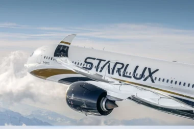 Commercial airliner in flight white fuselage with StarLux branding cruising above clouds