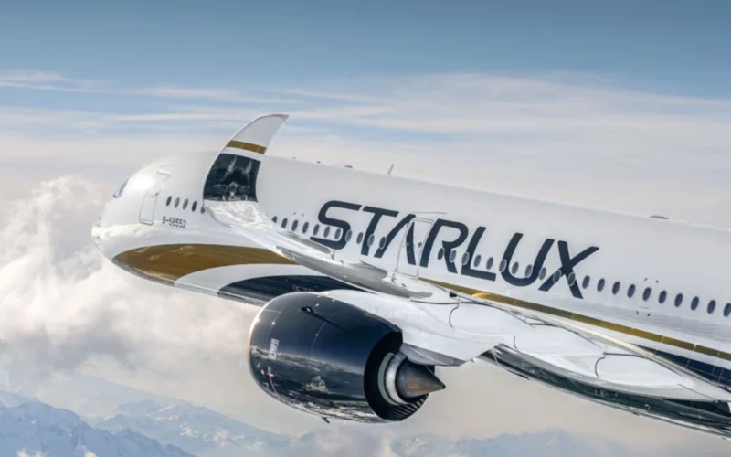 Commercial airliner in flight white fuselage with StarLux branding cruising above clouds