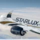 Commercial airliner in flight white fuselage with StarLux branding cruising above clouds