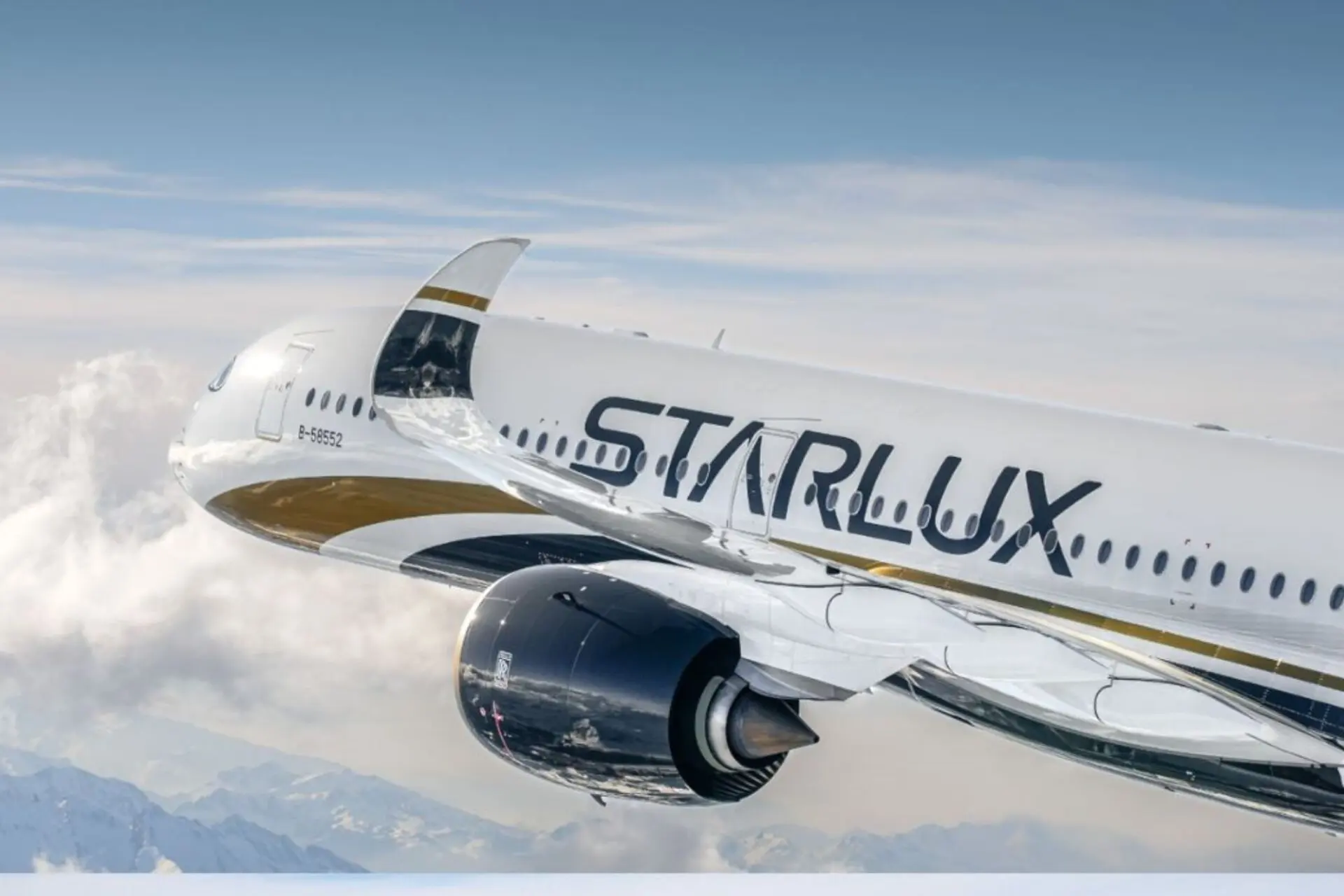 Commercial airliner in flight white fuselage with StarLux branding cruising above clouds