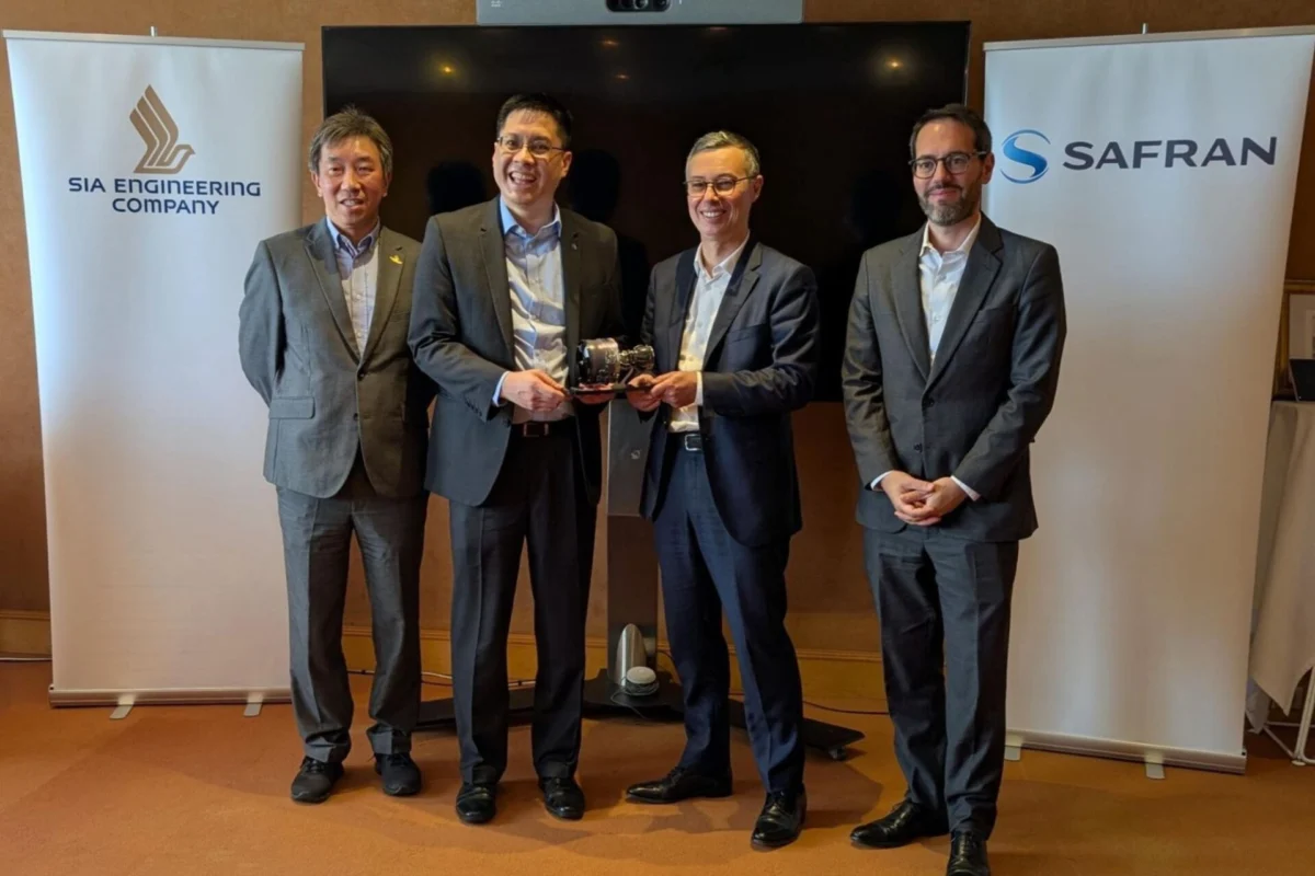 SIA Engineering and Safran team up for LEAP engine MRO Four men in business suits stand side by side at a bannered event two of them handing a small trophy to each other as a presentation moment