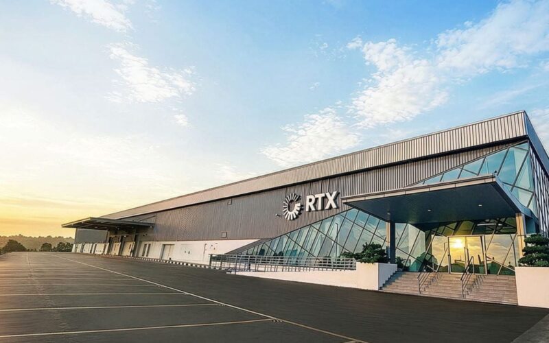 Collins Aerospace invests USM in Malaysia MRO expansion Modern RTX building with glass atrium and metal siding empty parking lot at sunrise
