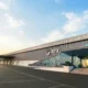 Modern RTX building with glass atrium and metal siding empty parking lot at sunrise