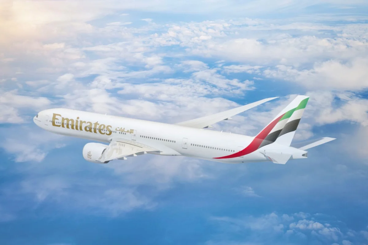 Emirates boosts Dubai Accra service to 11 weekly flights Emirates passenger jet in flight above the clouds tail fin with red green white and black stripes