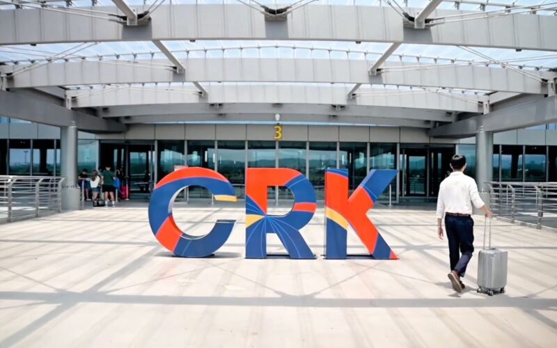CRK to expand with second runway Lufthansa investment Colorful large letters spelling GRK on a sunny plaza outside a modern glass front building a man with a rolling suitcase walks by