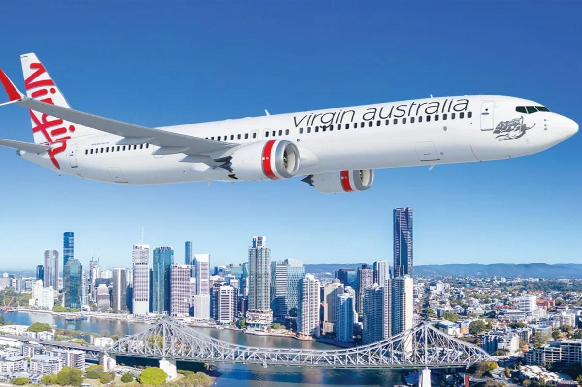 Virgin Australia Boeing 737 10 aircraft Virgin Australia passenger jet in flight over a city skyline with a river and bridge below against a clear blue sky