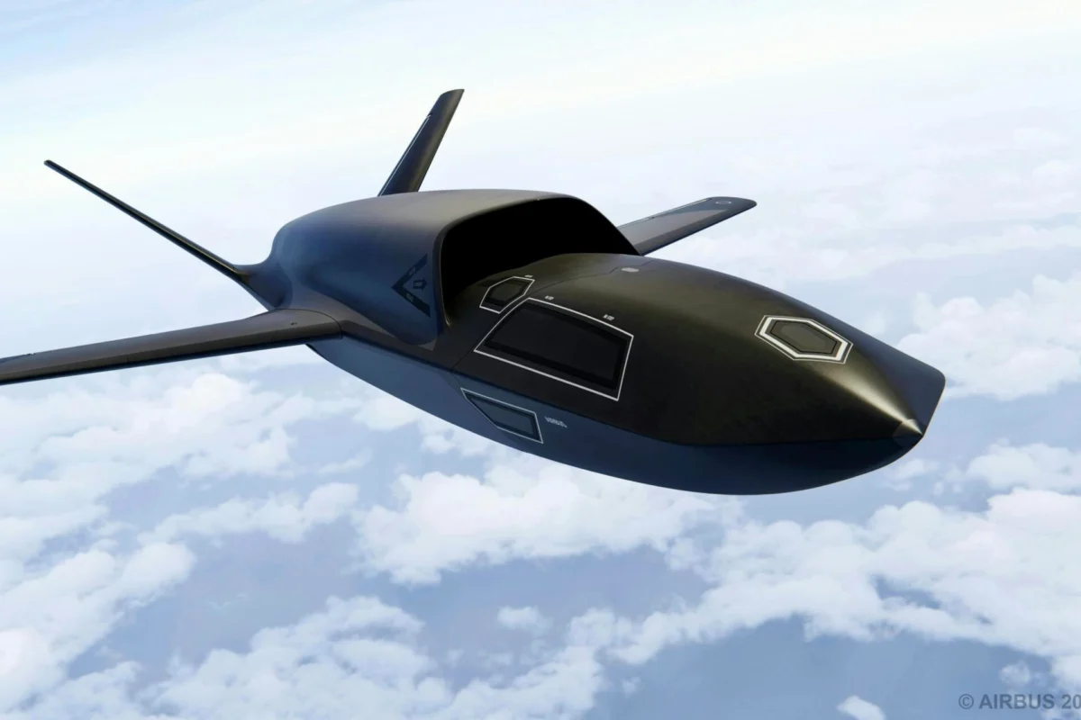 Dark sleek unmanned aircraft with swept back wings flying above clouds in a clear sky
