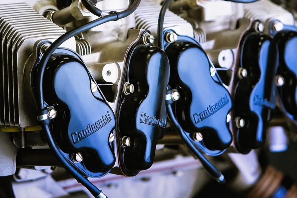 Close up of an engine with multiple cylinders and blue Continental valve covers labeled Continental