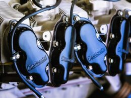 Close up of an engine with multiple cylinders and blue Continental valve covers labeled Continental