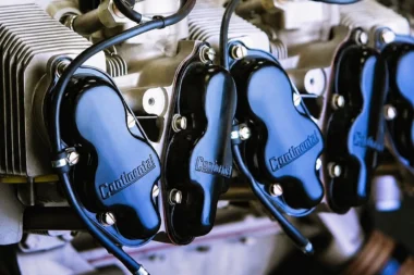 Close up of an engine with multiple cylinders and blue Continental valve covers labeled Continental