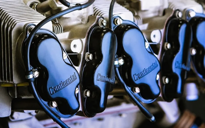 Close up of an engine with multiple cylinders and blue Continental valve covers labeled Continental