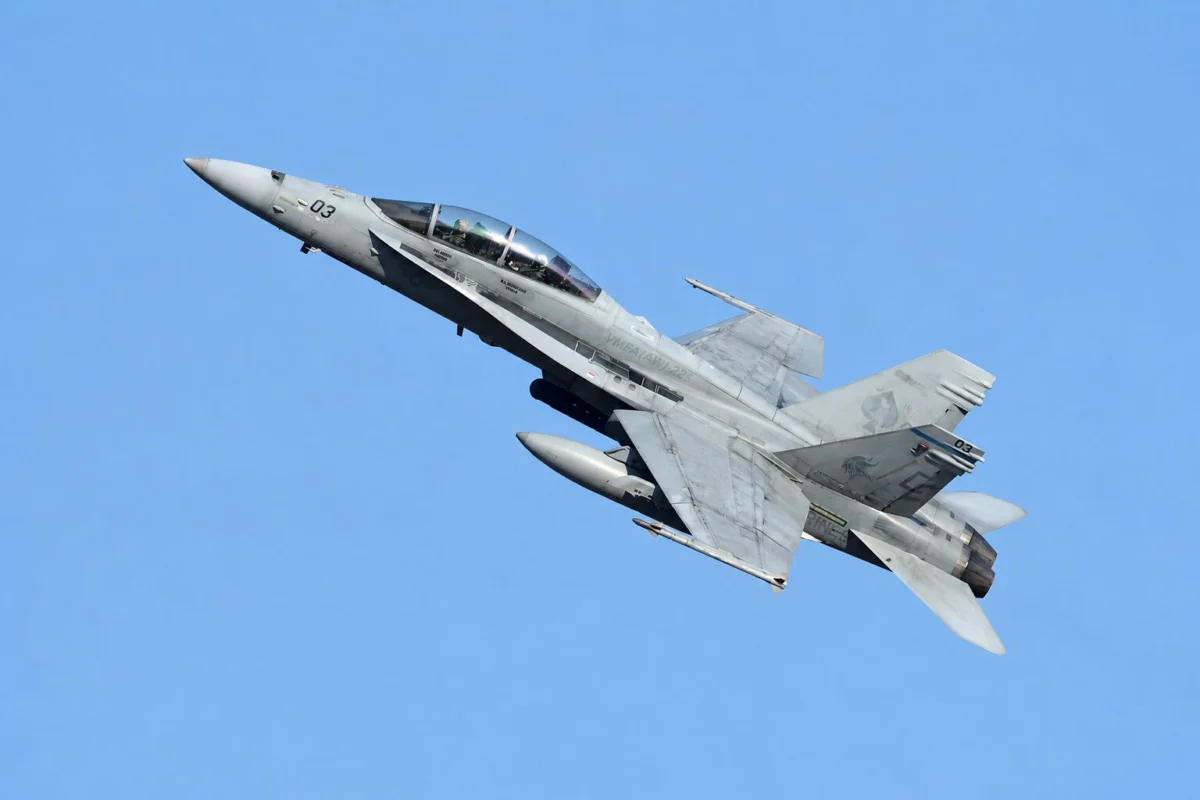 f1832 Twin seat military fighter jet banking to the left against a clear blue sky cockpit canopy visible with two pilots inside
